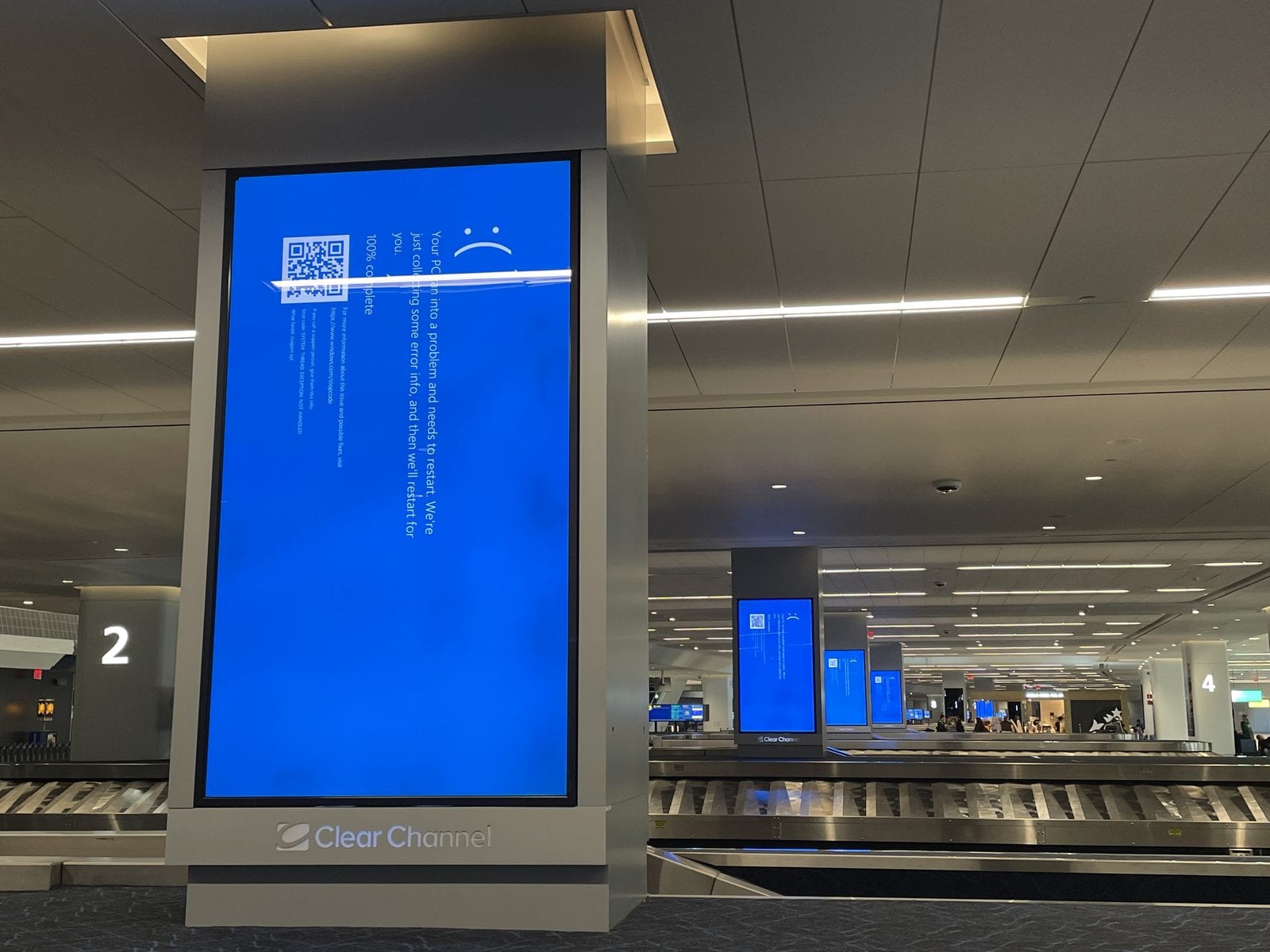 A row of blue-screen error messages on baggage-claim information displays at LaGuardia Airport, photographed the morning of the outage.