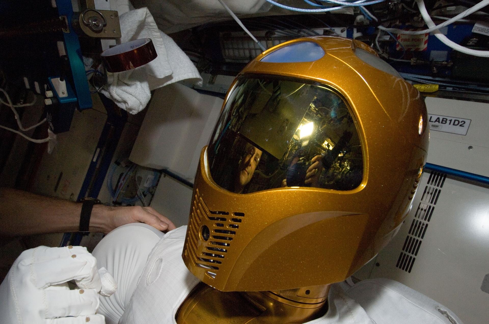 Close-up of Robonaut 2’s helmeted head, its onboard camera visible in the visor housing, aboard the International Space Station.