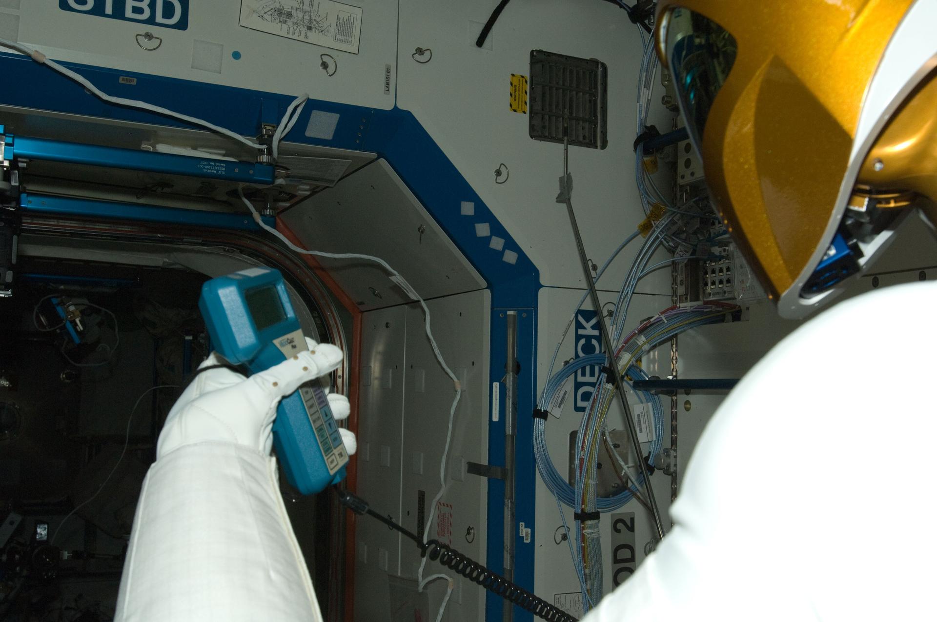 NASA’s Robonaut 2 humanoid robot holding a handheld instrument to take a measurement aboard the International Space Station.